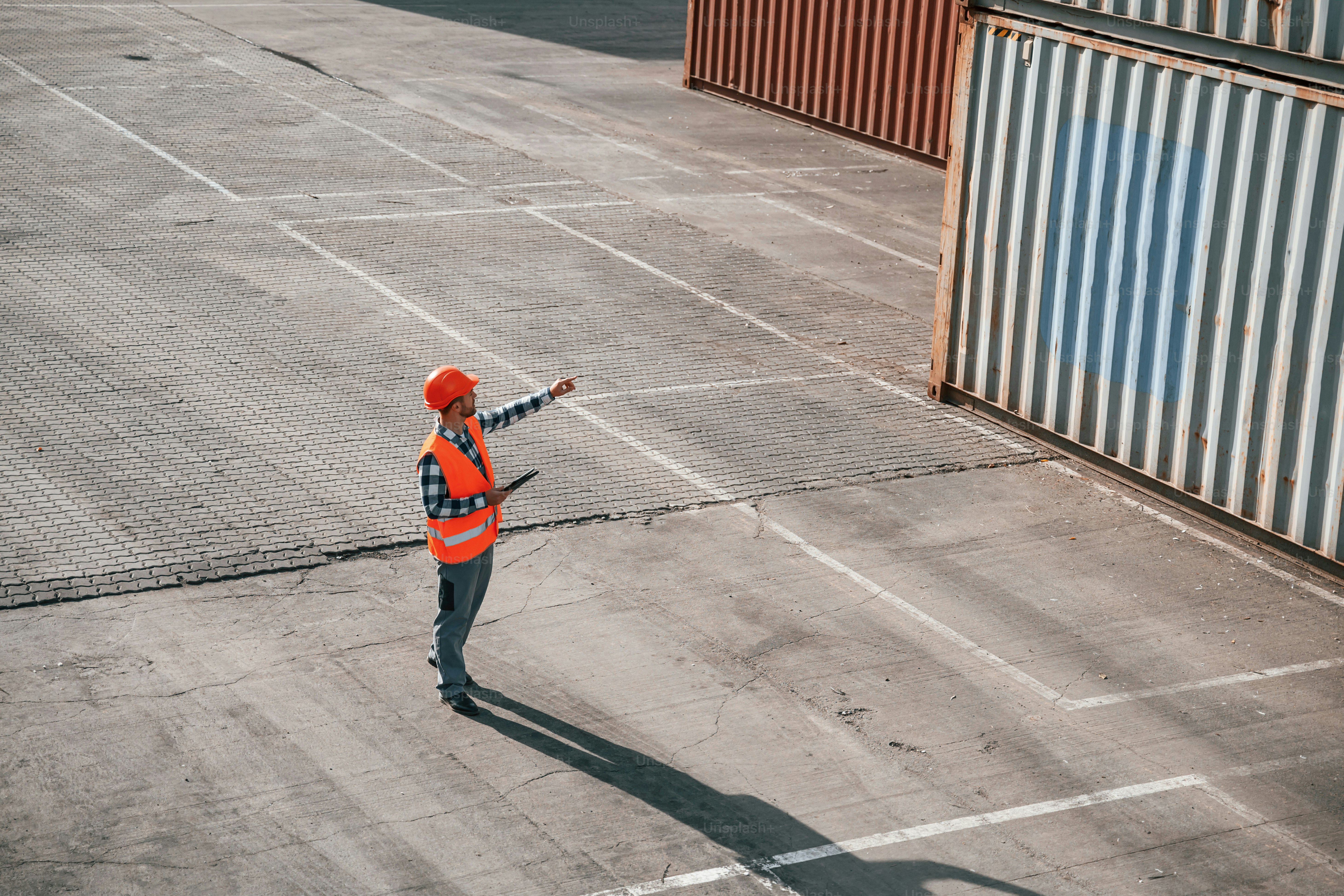 Konzeption des Geschäfts. Wandern mit Tablet. Männlicher Arbeiter ist mit Containern vor Ort.