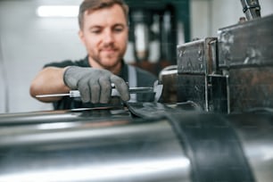 Clean parts. Man in uniform is in workstation developing details of agriculture technique.