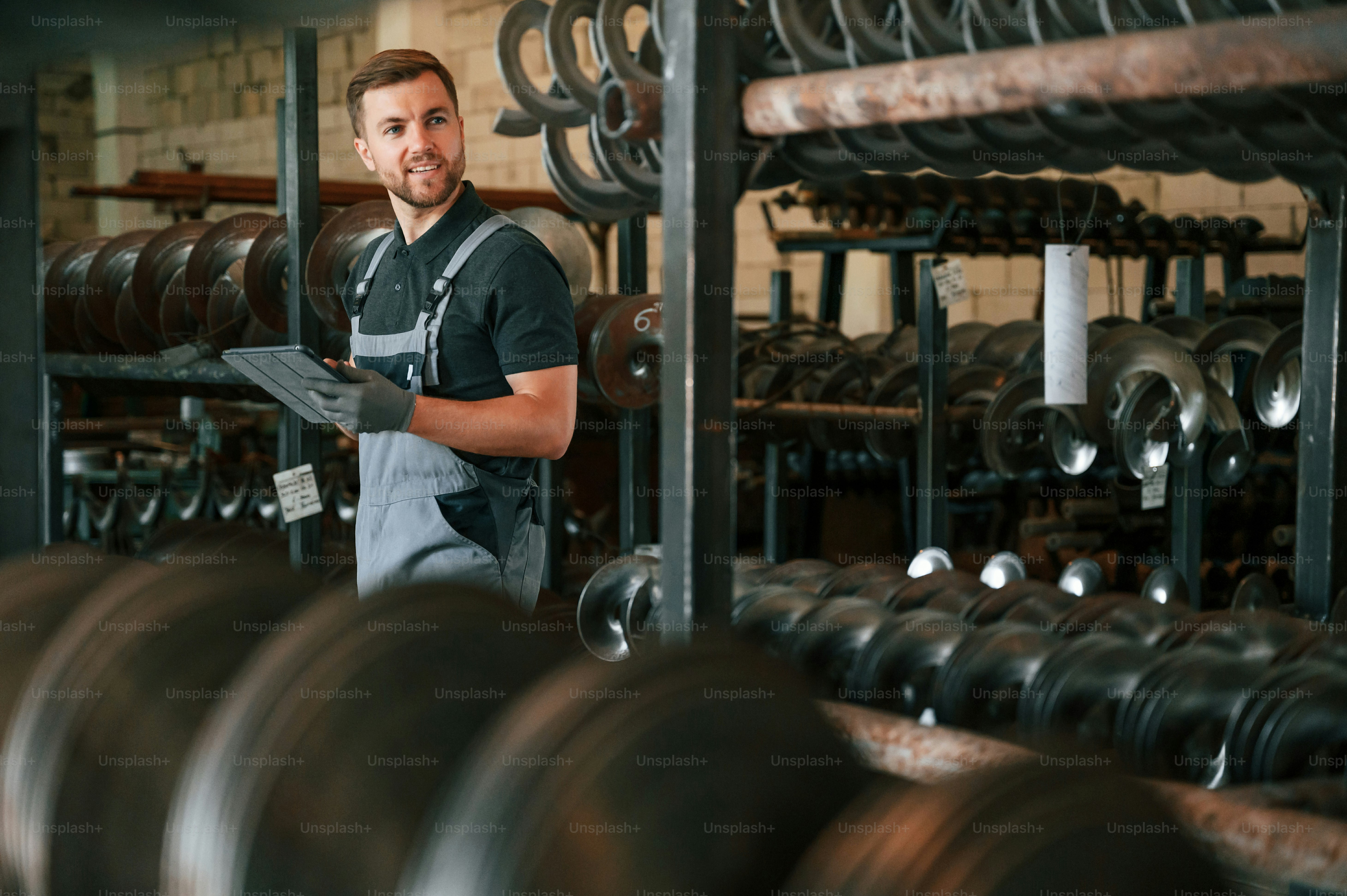 Verificação da qualidade dos produtos. Homem de uniforme está em estação de trabalho desenvolvendo detalhes da técnica agrícola.