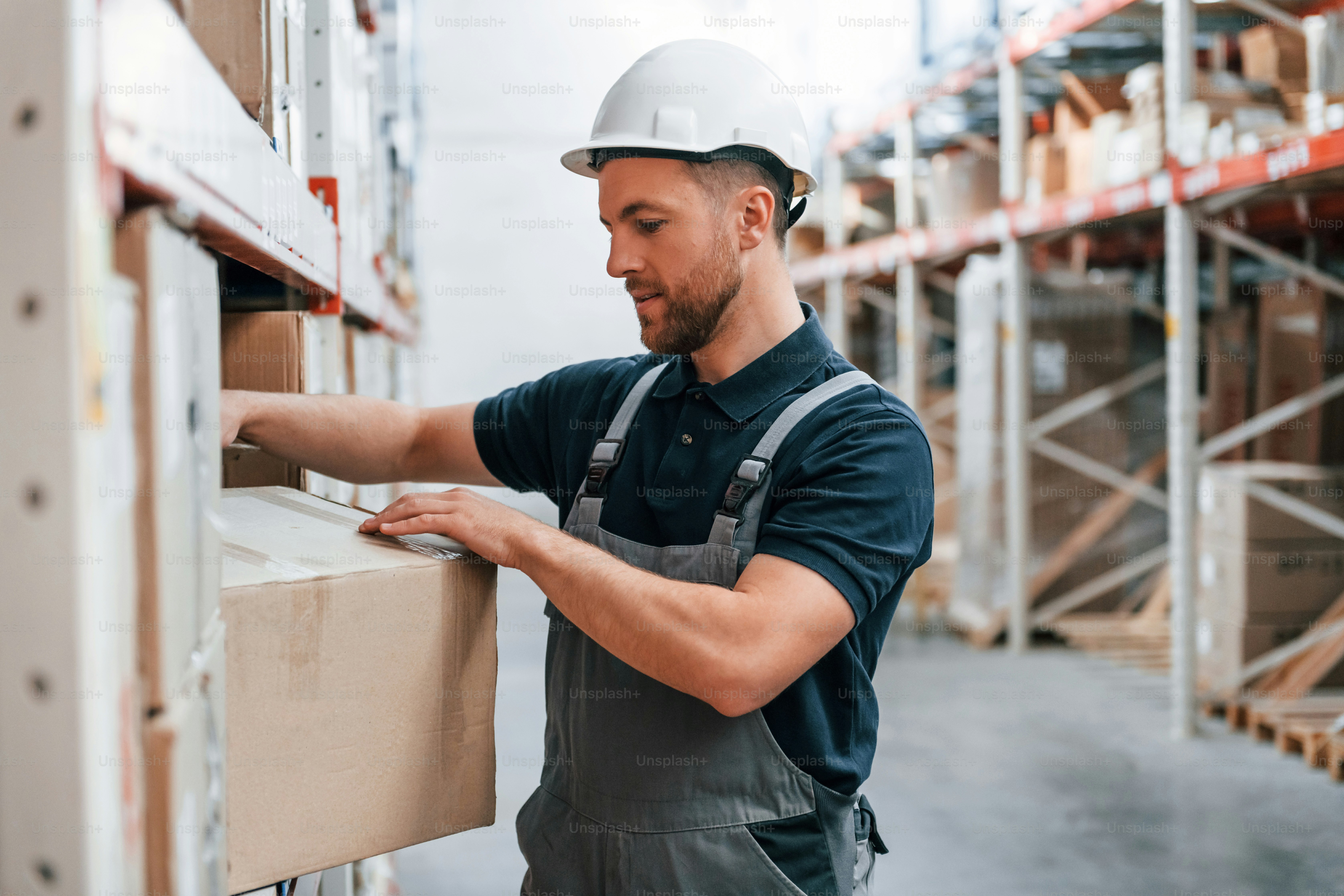 Manager is in the store. Employee in uniform is working in the storage at daytime.