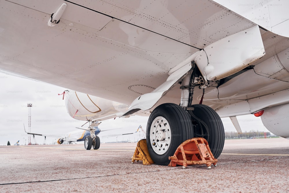 View from below. Turboprop aircraft parked on the runway at daytime.