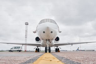 Front view. Turboprop aircraft parked on the runway at daytime.