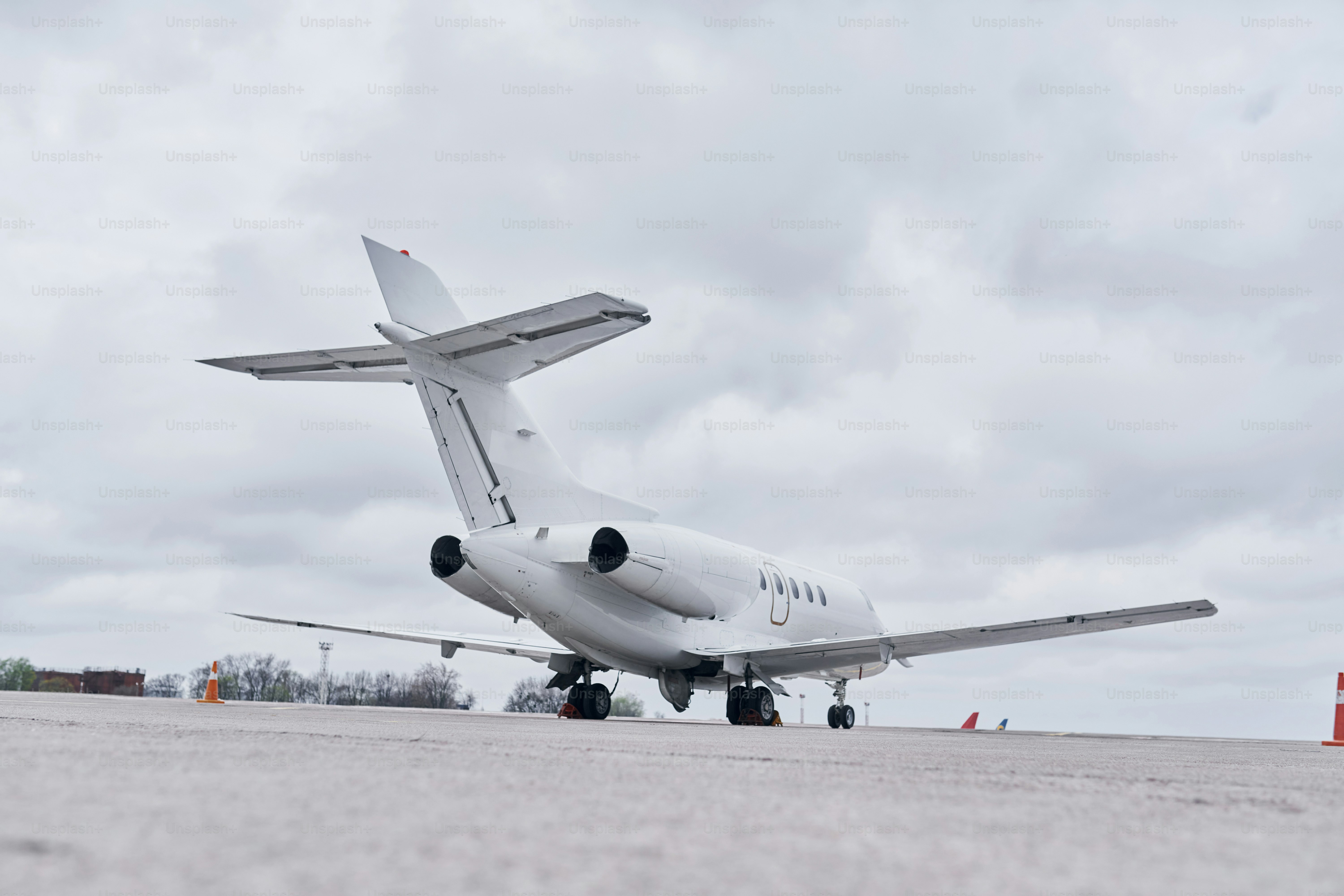 White plane. Turboprop aircraft parked on the runway at daytime.