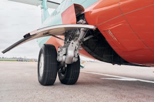 Close up view of wheels. Turboprop aircraft parked on the runway at daytime.