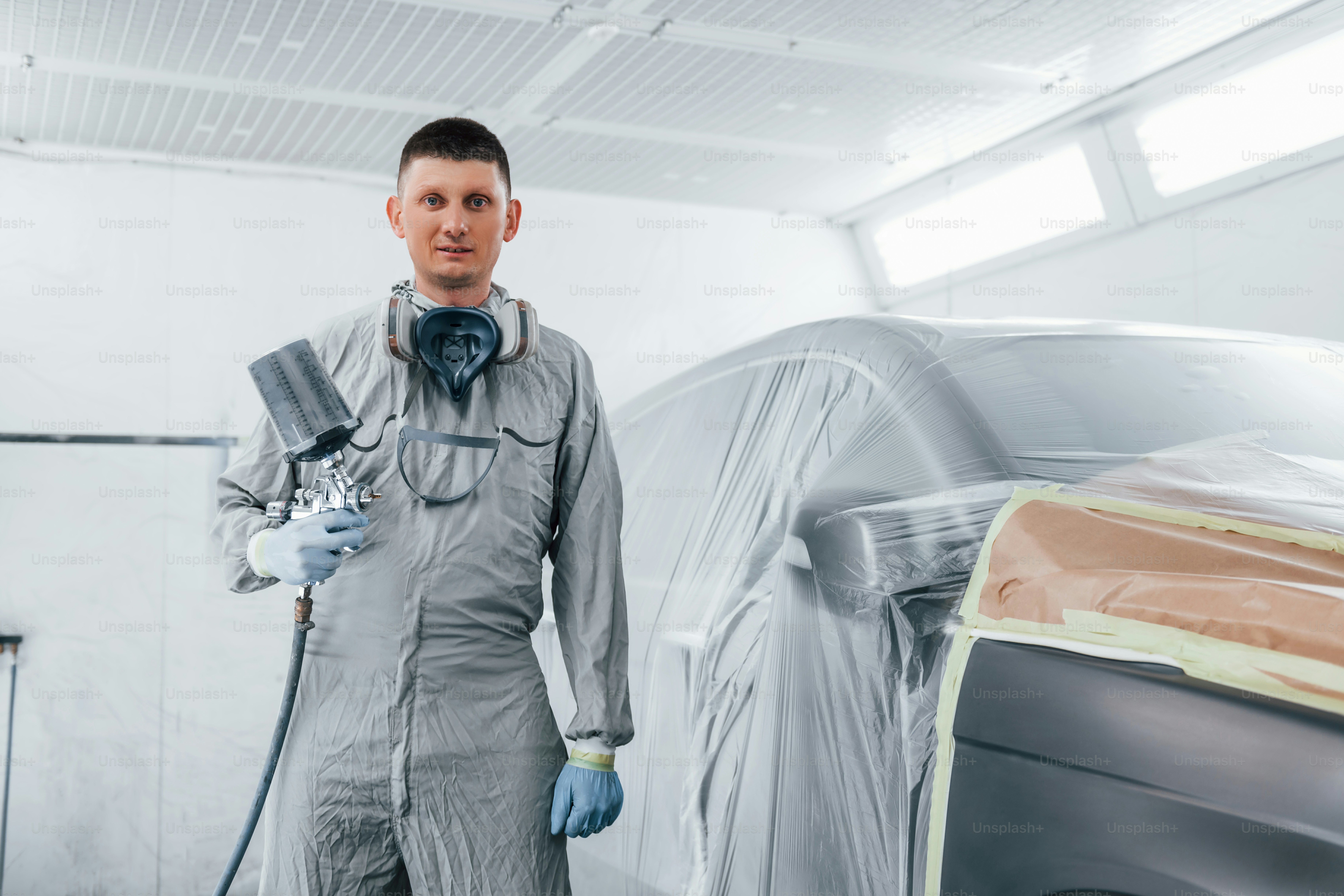 Kaukasischer Automechaniker in Uniform arbeitet in der Garage.