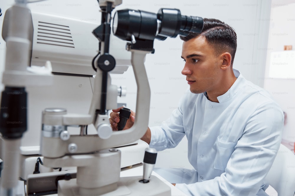 Oculist prueba la visión del paciente mediante el uso de una máquina moderna especial.
