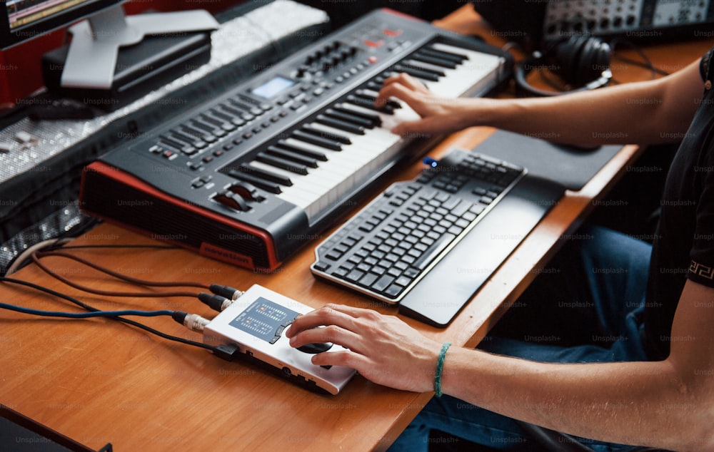 Jouer au clavier midi. Ingénieur du son travaillant et mixant de la musique à l’intérieur dans le studio.