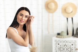 Beauty care, home procedures at morning during covid-19 lockdown, be safety and new normal. Cheerful young cute european female plucking eyebrows, on white bedroom interior background, copy space