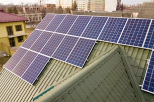 Superficie ravvicinata del sistema di pannelli fotovoltaici solari lucidi blu sul tetto dell'edificio. Concetto di produzione di energia verde ecologica rinnovabile.