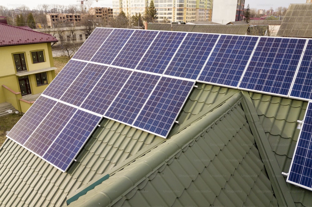 Superficie ravvicinata del sistema di pannelli fotovoltaici solari lucidi blu sul tetto dell'edificio. Concetto di produzione di energia verde ecologica rinnovabile.