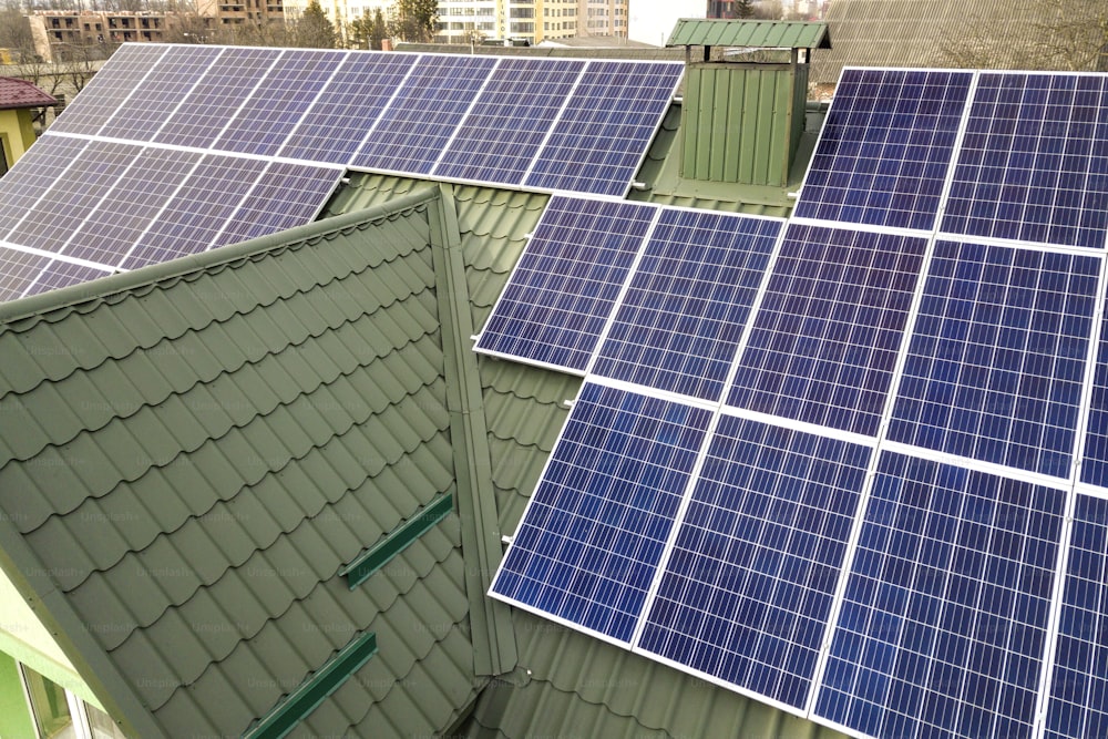 Nahaufnahme der blau glänzenden Photovoltaik-Paneele auf dem Dach des Gebäudes. Erneuerbares ökologisches Konzept zur Erzeugung grüner Energie.