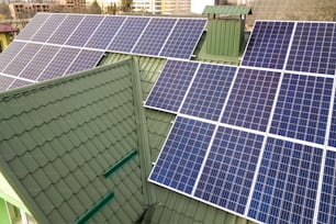 Gros plan du système de panneaux photovoltaïques solaires bleus brillants sur le toit du bâtiment. Concept de production d’énergie verte écologique renouvelable.