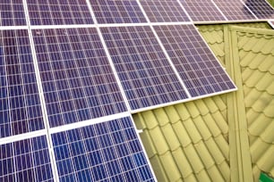 Superficie ravvicinata del sistema di pannelli fotovoltaici solari lucidi blu sul tetto dell'edificio. Concetto di produzione di energia verde ecologica rinnovabile.