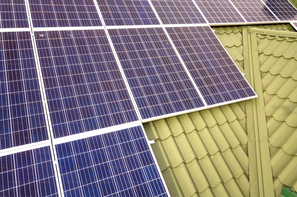 건물 지붕에 있는 파란색 반짝이는 태양광 발전 패널 시스템의 클로즈업 표면. 재생 가능한 생태 녹색 에너지 생산 개념.