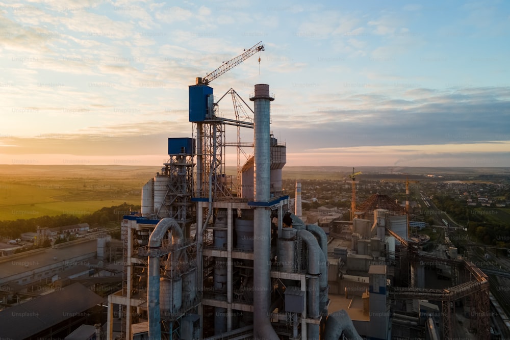 Luftaufnahme des Zementfabrikturms mit hoher Betonwerksstruktur im industriellen Produktionsbereich. Fertigungs- und globales Industriekonzept.