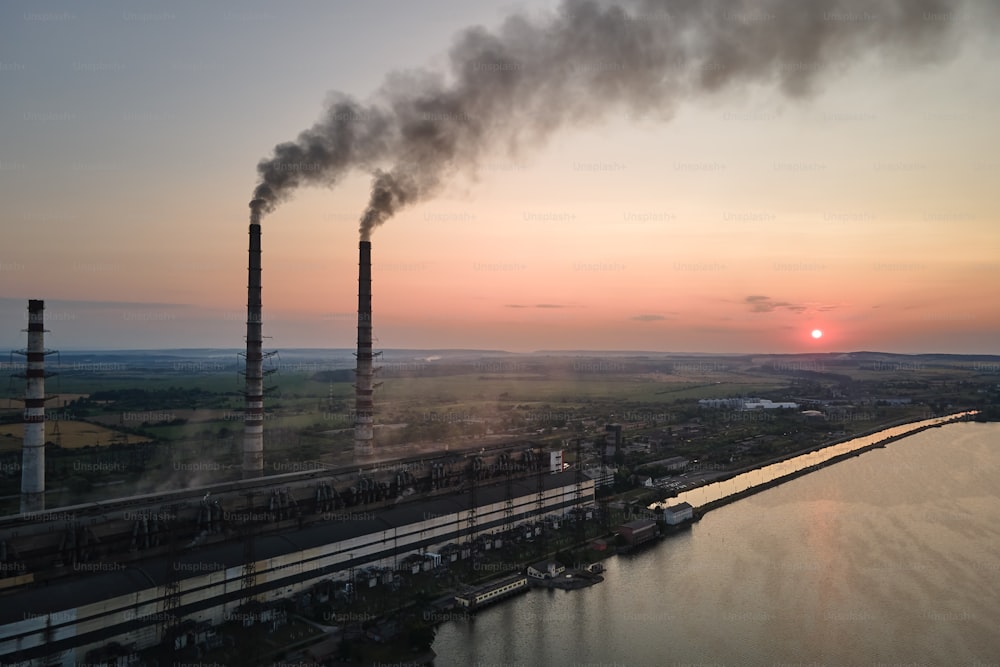 Aerial view of coal power plant high pipes with black smokestack polluting atmosphere. Electricity production with fossil fuel concept.