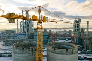높은 공장 구조와 산업 생산 지역의 타워 크레인을 갖춘 시멘트 공장의 조감도.
