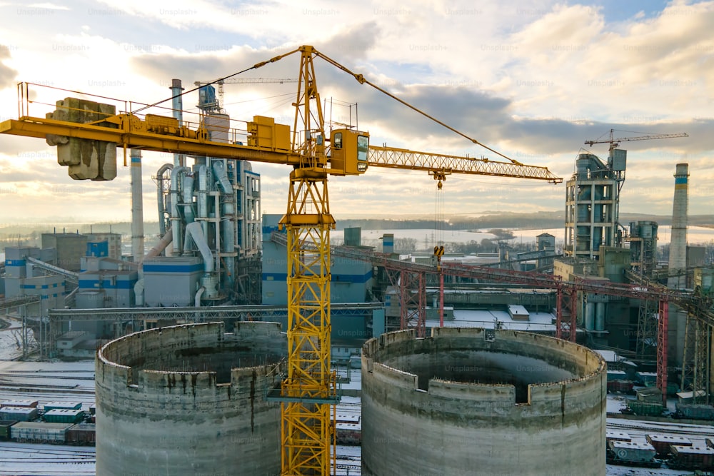 Luftaufnahme des Zementwerks mit hoher Fabrikstruktur und Turmdrehkran im industriellen Produktionsbereich.