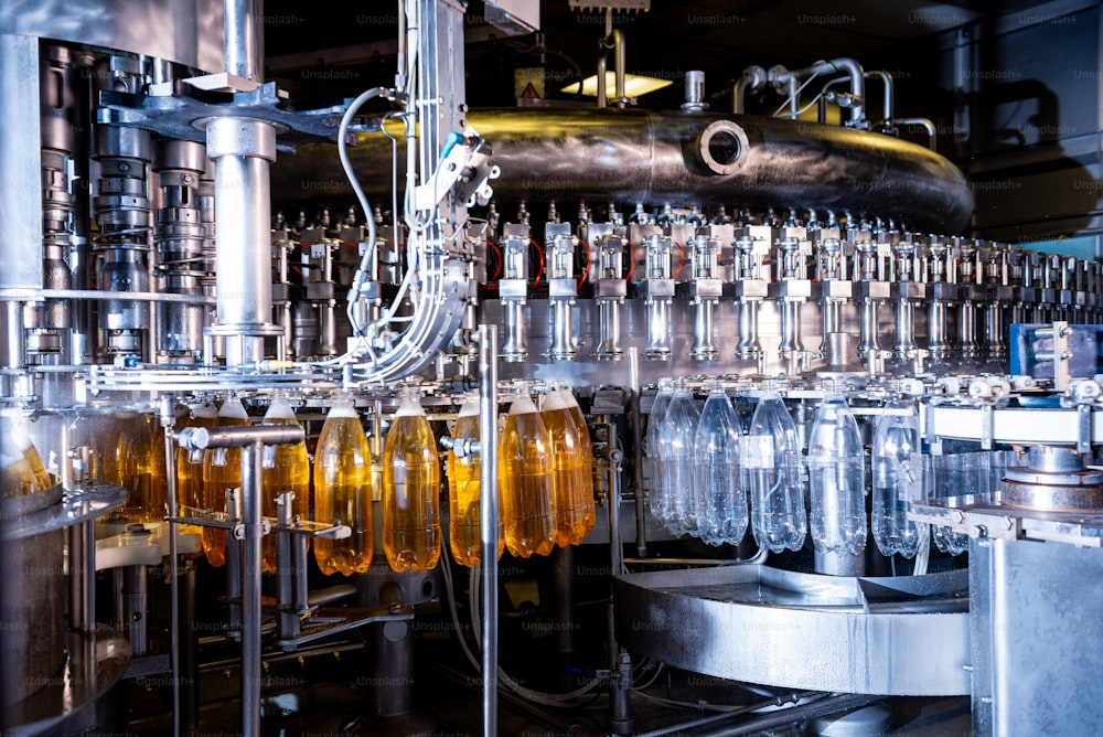 La riempitrice automatica versa acqua in bottiglie di plastica PET in un moderno impianto di produzione di bevande