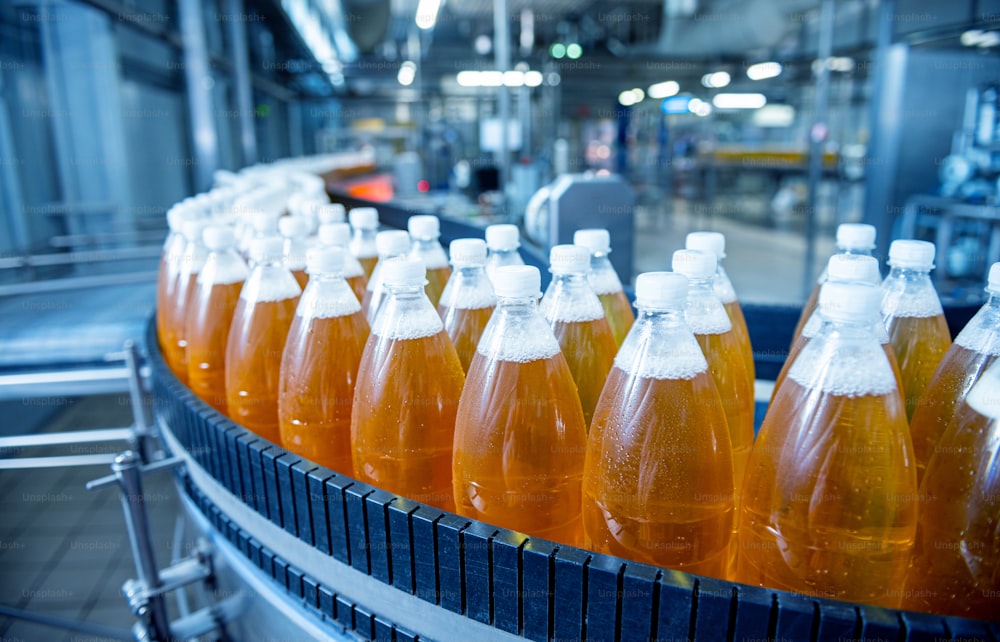 Conveyor belt with bottles for juice or water at a modern beverage plant.