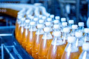 Conveyor belt with bottles for juice or water at a modern beverage plant.
