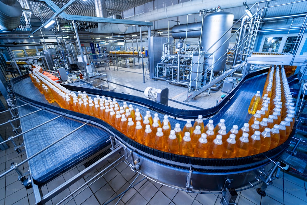 Conveyor belt with bottles for juice or water at a modern beverage plant.