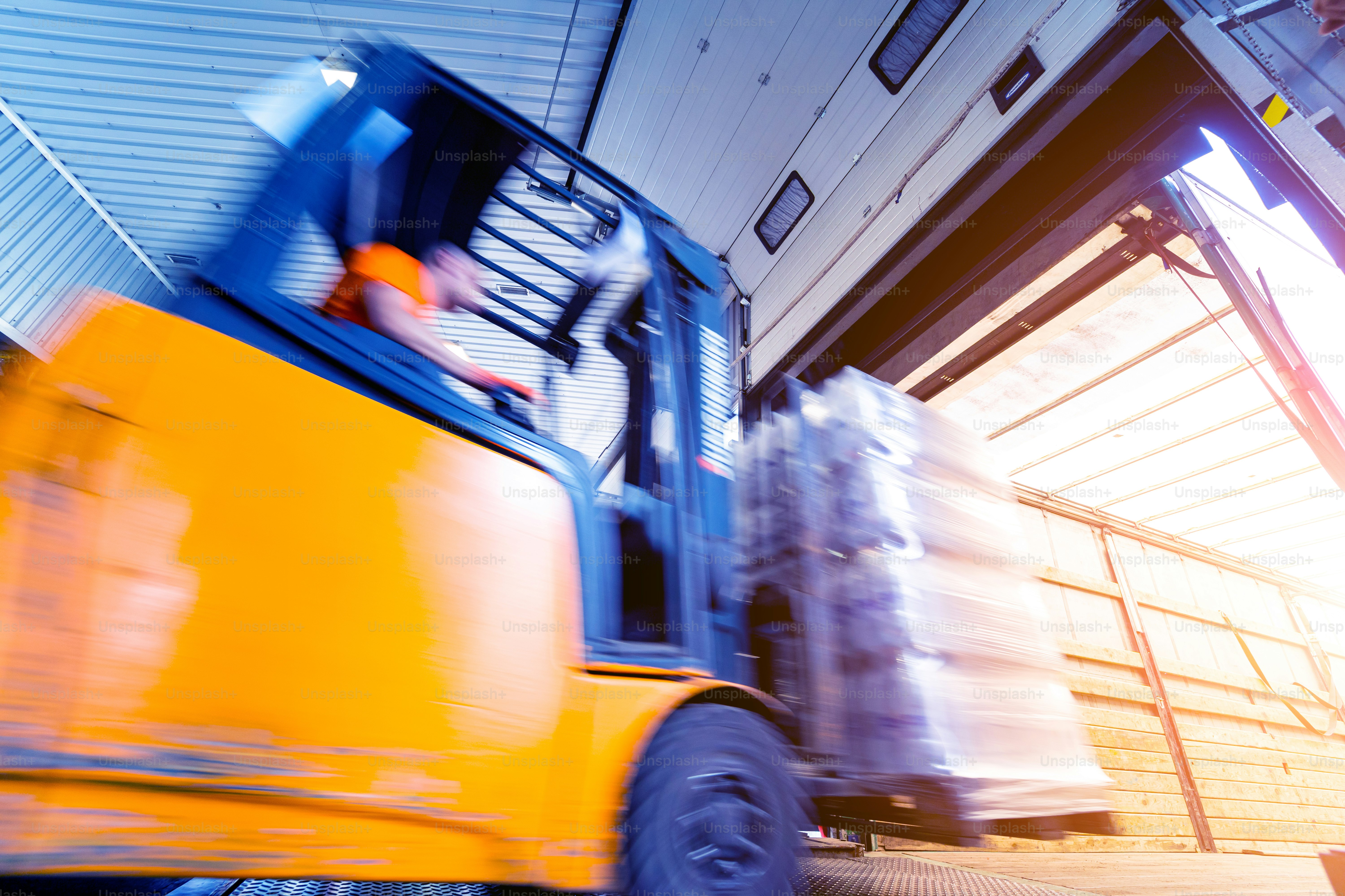 Forklift loader working at beverages plant warehouse.