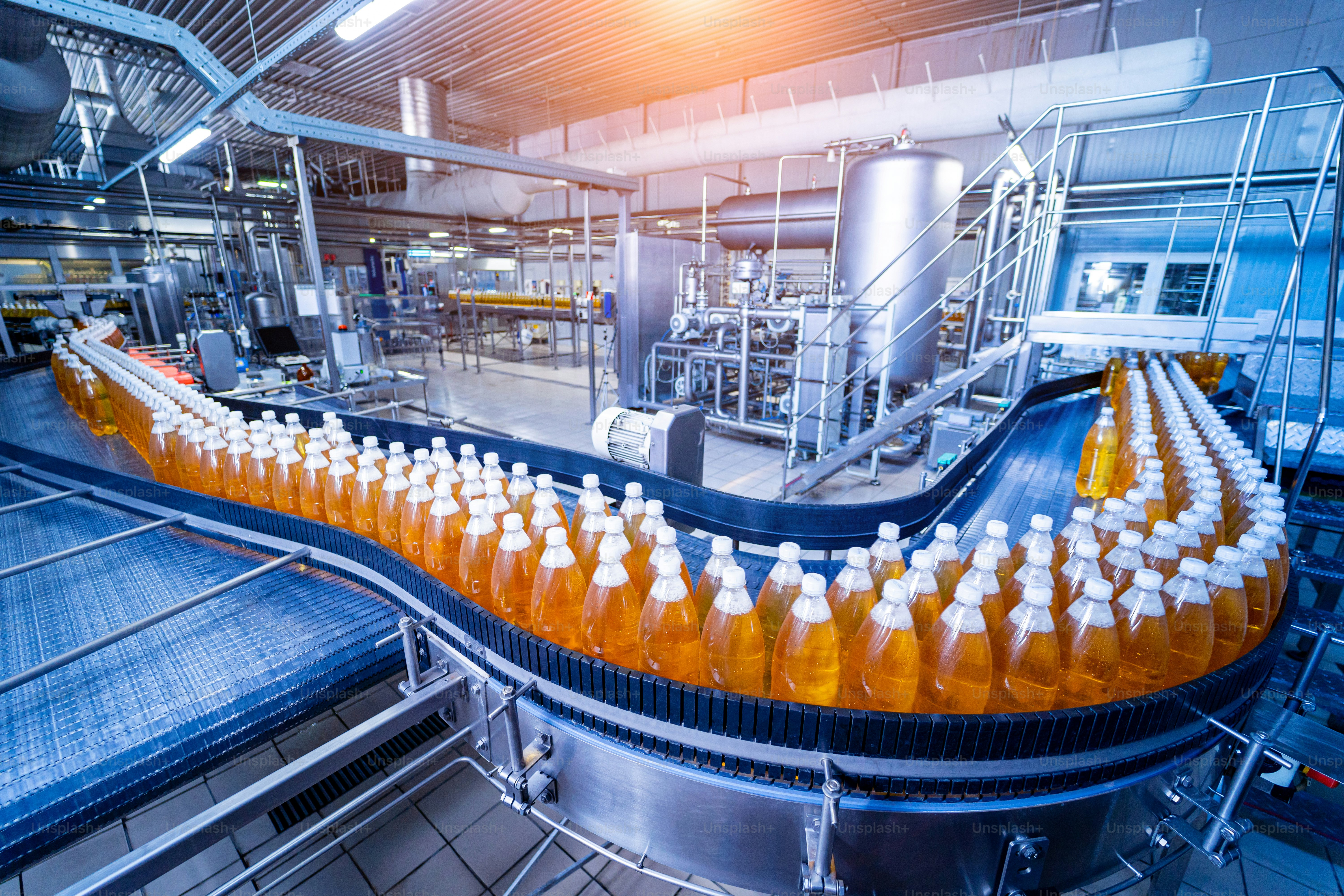 Conveyor belt with bottles for juice or water at a modern beverage plant.