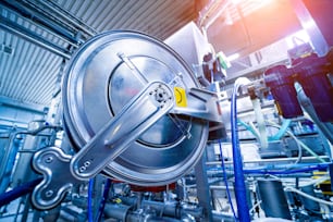 Modern interior of a beverage plant with barrels and pipes.