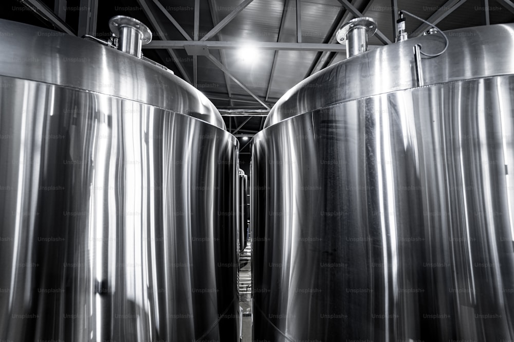 Fileiras de tanques de aço para fermentação e maturação de cerveja em uma cervejaria artesanal.