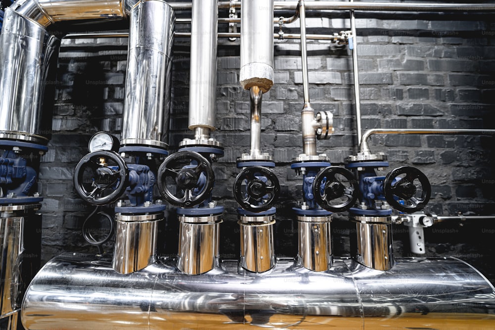 The valves and pipes at a craft modern brewery wall.