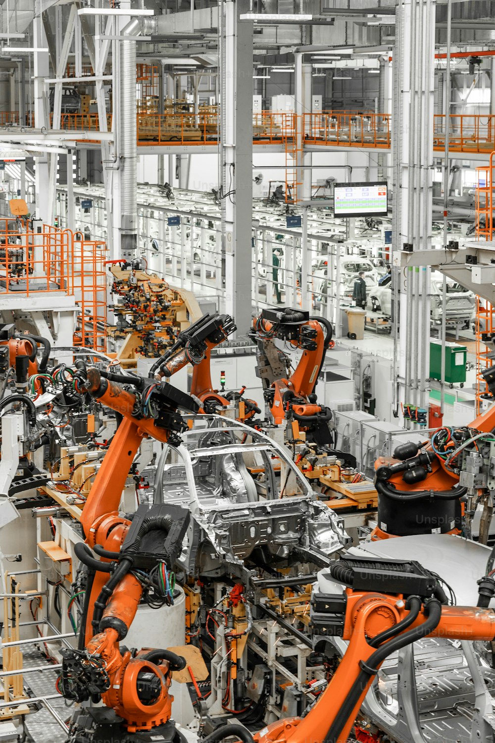Vertical photo of automobile production line. Modern car assembly plant. Auto industry. Interior of a high-tech factory, modern production.