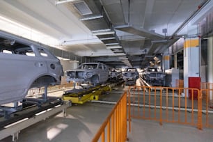 Car bodies are on assembly line. Modern automotive industry. A car being checked before being painted in a high-tech enterprise.