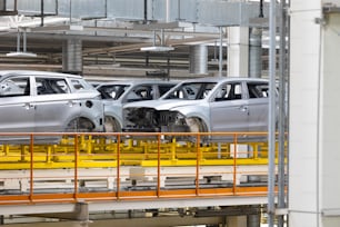 Photo of automobile production line. Modern car assembly plant. Modern and high-tech automotive industry. Conveyor of auto bodies.