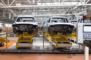 Photo of automobile production line. Welding car body. Modern car assembly plant. Auto industry. Interior of a high-tech factory.