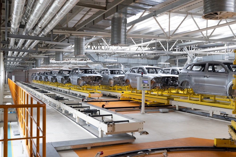 As carrocerias dos carros estão em linha de montagem. Fábrica para produção de automóveis. Indústria automotiva moderna.