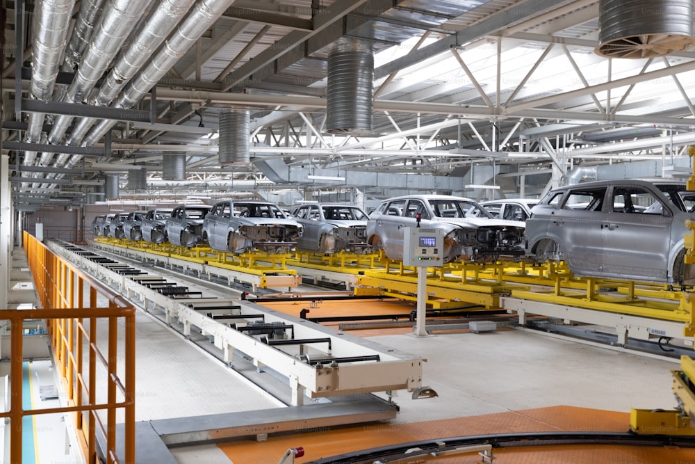 Car bodies are on assembly line. Factory for production of cars. Modern automotive industry.