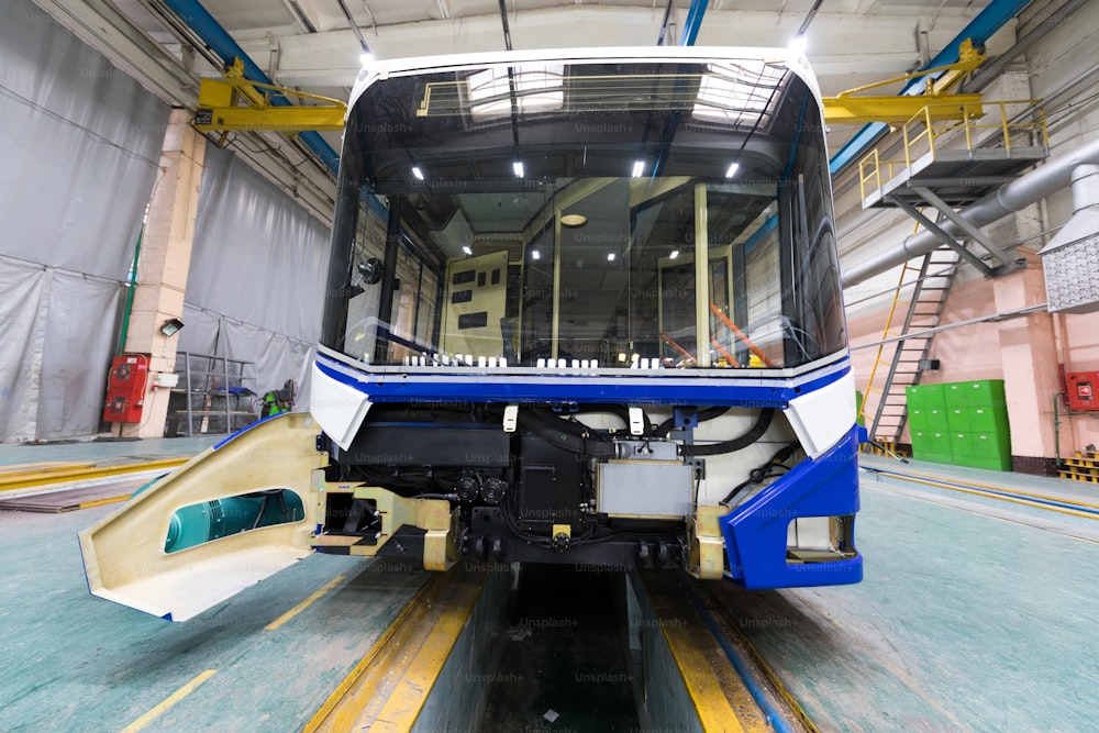 One working day of modern automatic bus manufacturing with unfinished cars workers in protective uniform automobile production