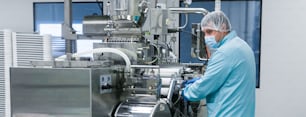 widescreen photo, factory worker in gas mask works with machine