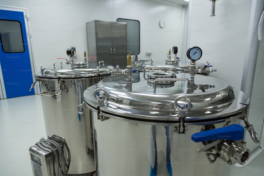 Tanque cromado de acero con medidor de presión en laboratorio limpio