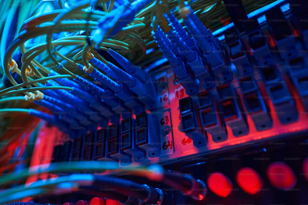 Câbles à fibre optique bleue insérés dans les ports du panneau de commutation à l’intérieur du rack du serveur