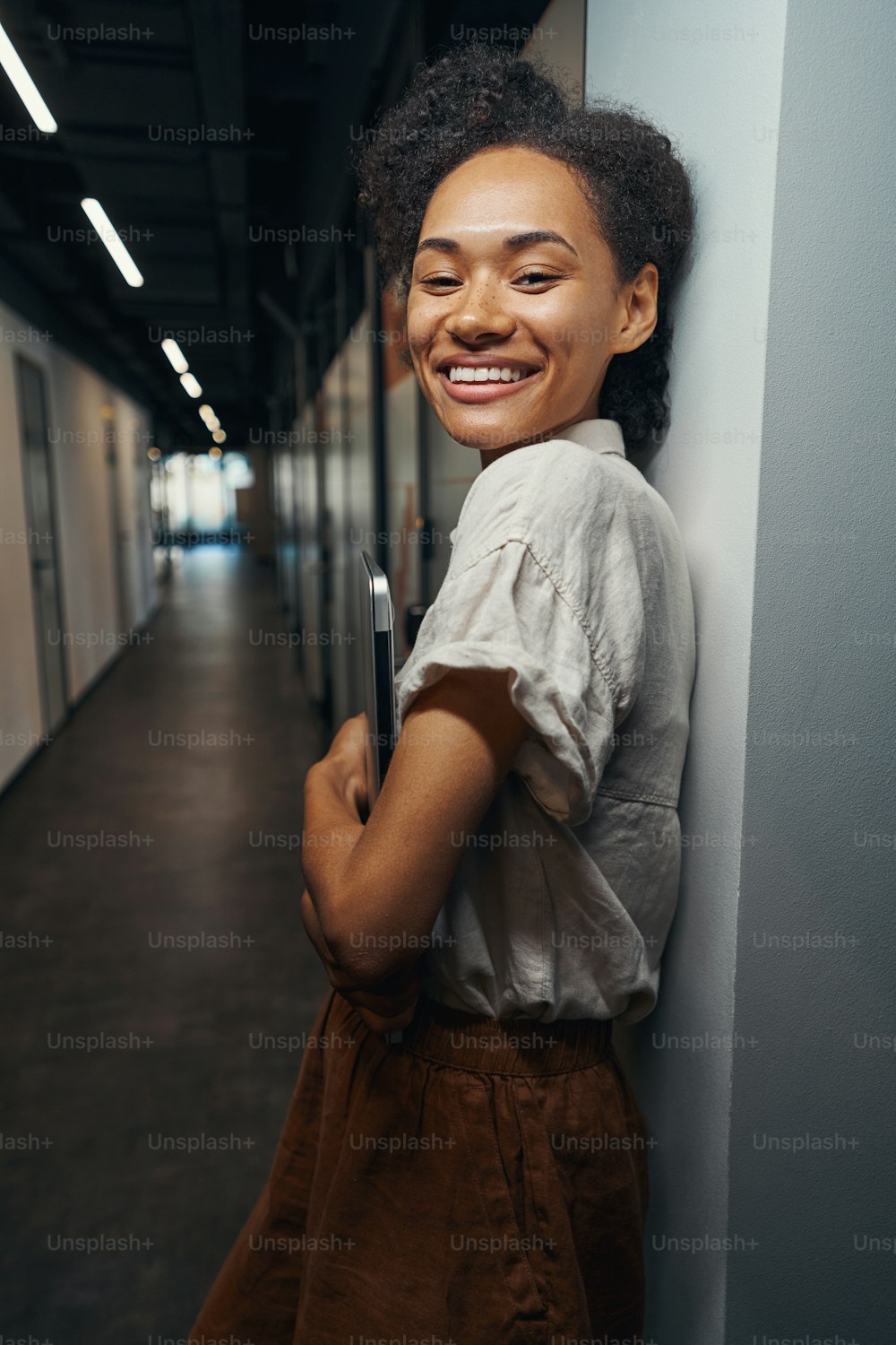 Persona femenina feliz parada en el pasillo y esperando a su colega