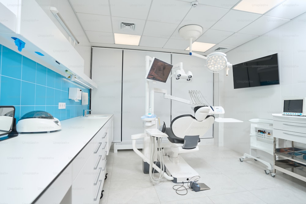 患者のための空の革張りの椅子を備えた広々としたモダンな明るいプロの歯科医のオフィス