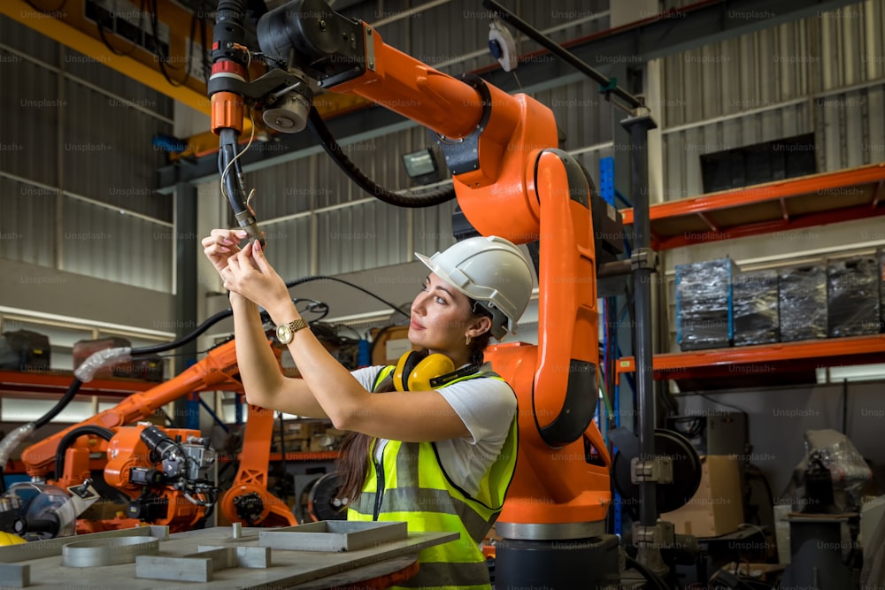 Engenheiro ou Trabalhador em fábrica industrial inteligente. Máquina de braços robóticos de verificação e controle de verificação e controle de automação em fábrica industrial inteligente