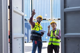 Professional foreman work at Container cargo site check up goods in container. Workers are opening containers for inspection and check.