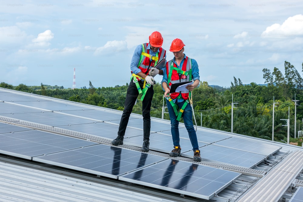 엔지니어는 옥상에 태양 전지판을 설치했습니다. 엔지니어 또는 작업자는 비즈니스 건물 옥상에서 태양 전지판 또는 태양 전지 작업을 합니다.