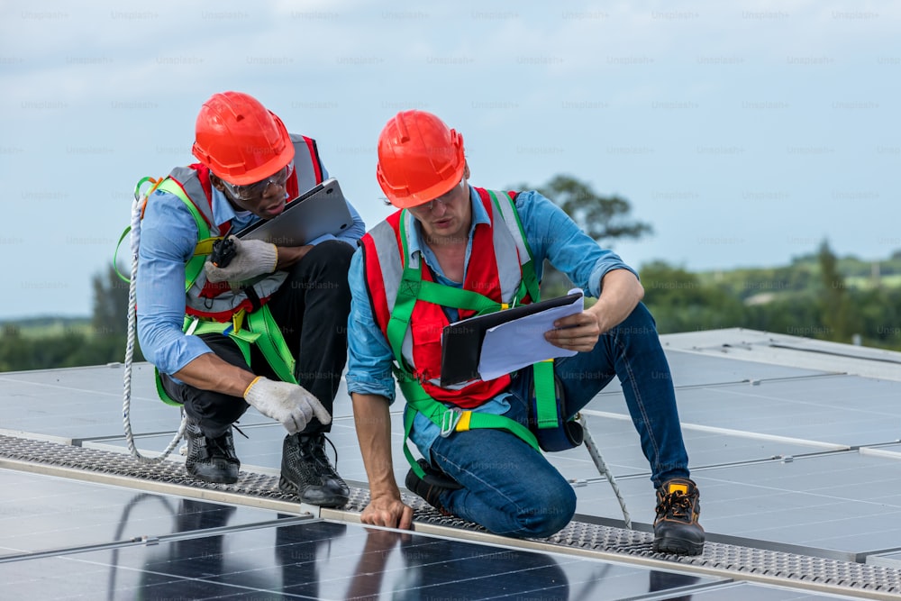Ingeniero de trabajo configura el panel solar en la azotea. El ingeniero o el trabajador trabajan en paneles solares o células solares en el techo de un edificio comercial