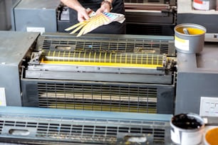 Typograf wählt eine Farbe aus Pantone-Mustern bei der Druckherstellung