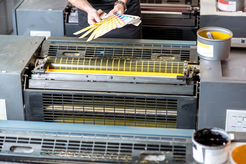 Typographer choosing a paint color from pantone swatches at the printing manufaturing