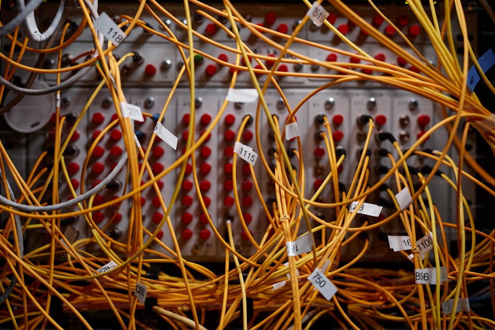 Immagine di sfondo ravvicinata dell'armadio del server con cavi Internet gialli e fili collegati alle porte, spazio di copia